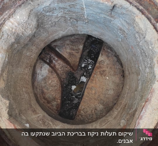 פתח ביוב עם צינור מתכת חלוד